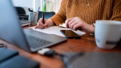 Frau sitzt mit einem laptop am tisch