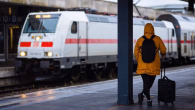 Reisende wartet bei regen und herbststurm am bahnhof auf den zug