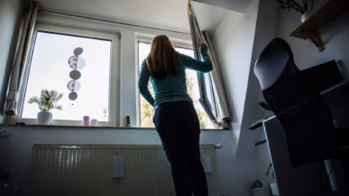 Frau öffnet zum lüften ein fenster