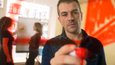 Mann malt zur visualisierung einen kreis an eine plexiglasscheibe