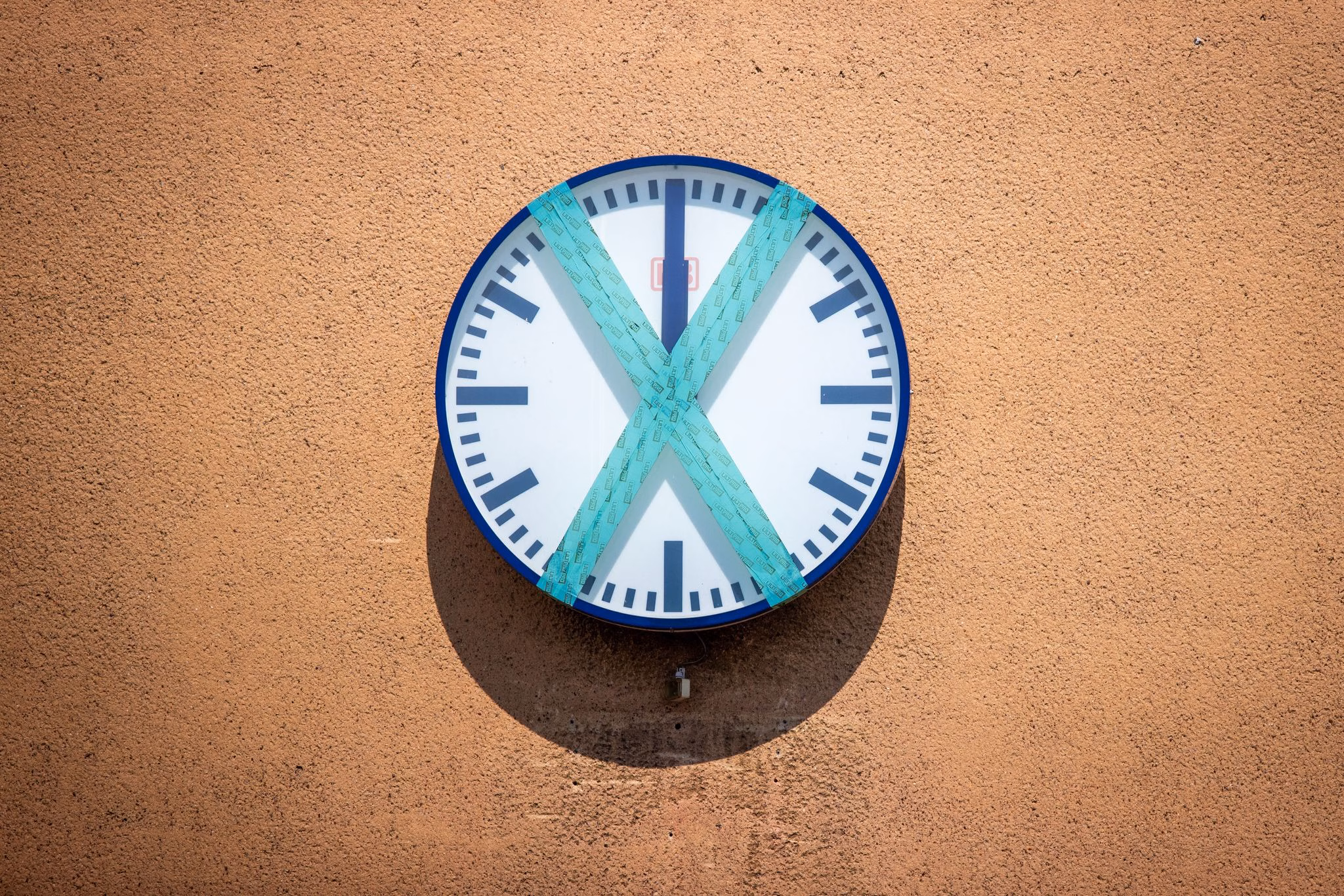 Eine abgeklebte bahnhofsuhr hängt an einer wand