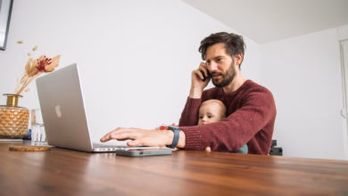 Mann mit kleinkind vor laptop