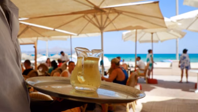Kellner serviert am strand einen wein