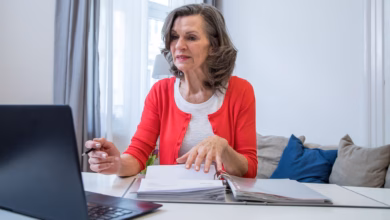 Eine ältere frau arbeitet am laptop.