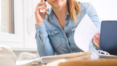 Eine frau telefoniert und liest unterlagen durch