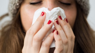 Frau hält sich ein papiertaschentuch vor das gesicht