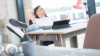 Mann schaut an seinem schreibtisch aus dem fenster