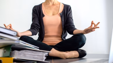 Eine frau sitzt im schneidersitz auf einem schreibtisch