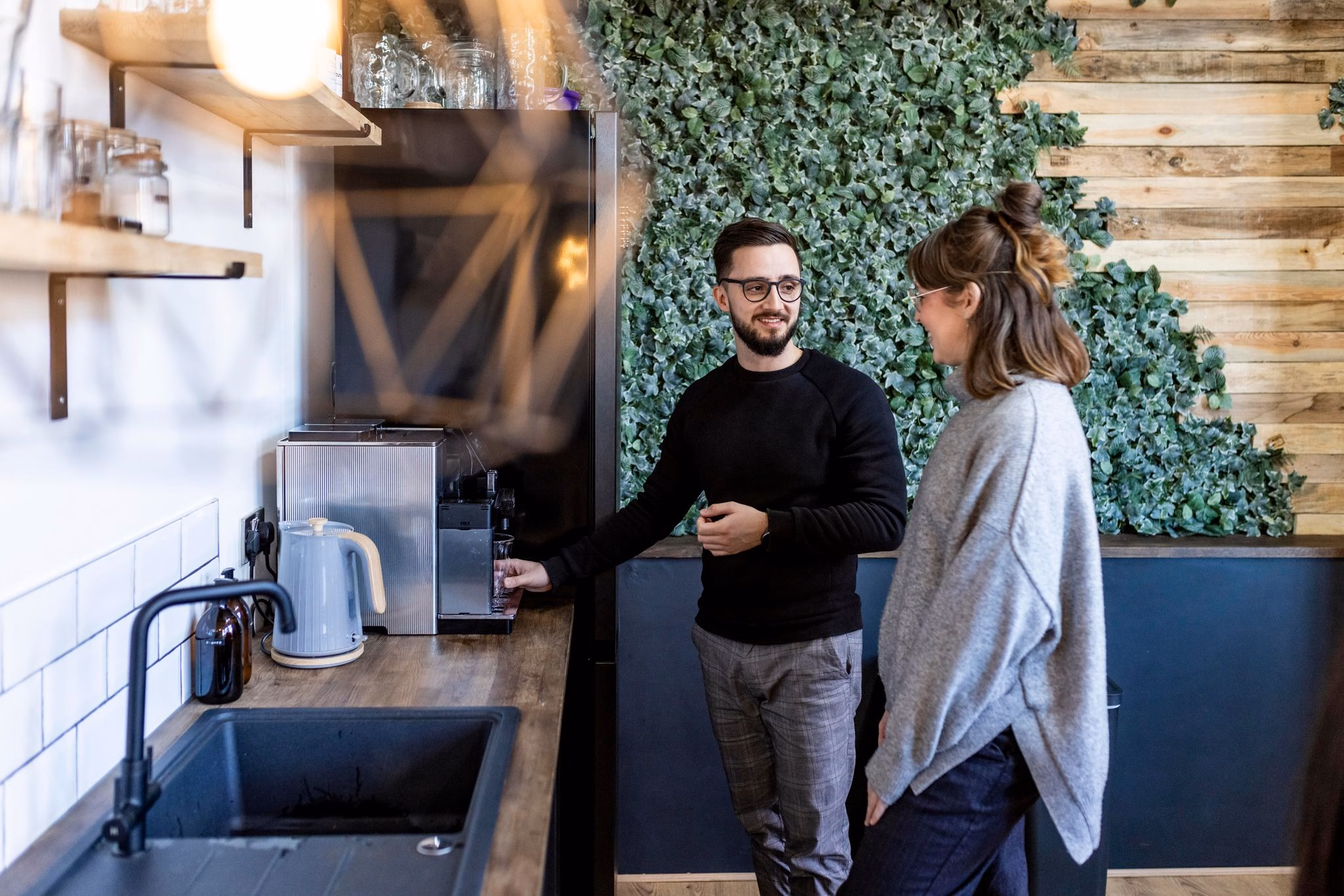 Kollegen unterhalten sich in der kaffeeküche