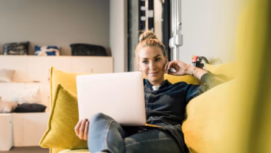 Frau sitzt mit laptop auf einer couch