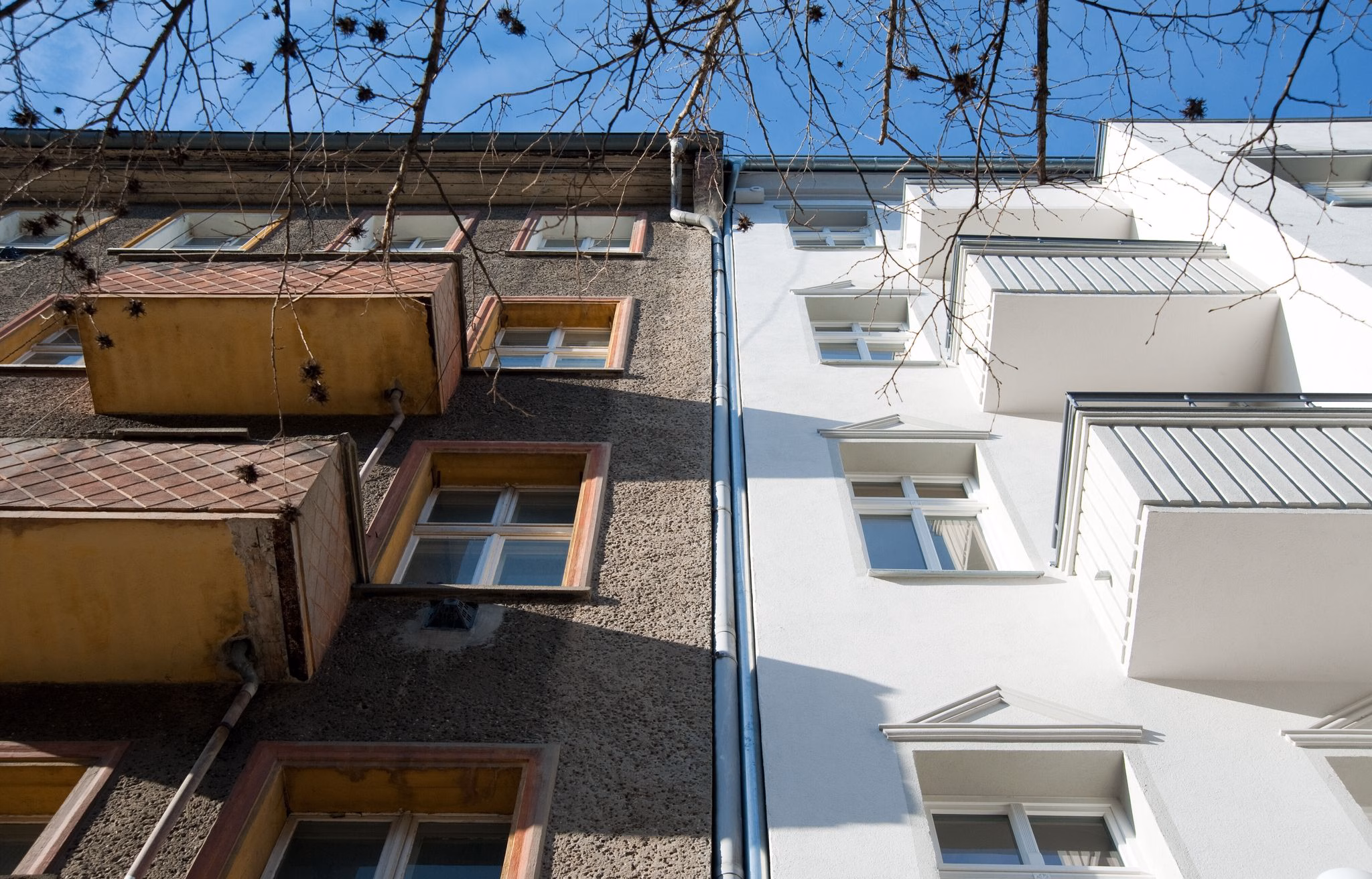 Ein unsaniertes mehrfamilienhaus neben einem sanierten haus