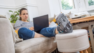 Eine frau mit fuß im gips auf dem sofa