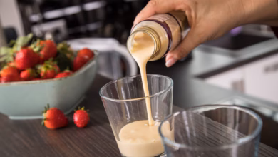 Eine frau gießt ein fertig getränk in ein glas
