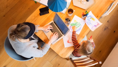 Eine frau arbeitetneben ihrem kind am laptop