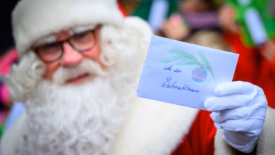 Weihnachtsmann hält weihnachtspost hoch