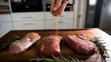 Eine perosn würzt fleisch