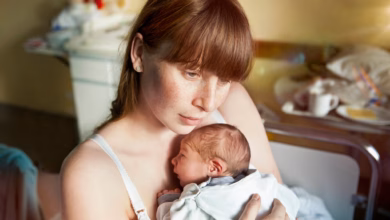 Eine junge mutter hält ihr neugeborenes in den armen