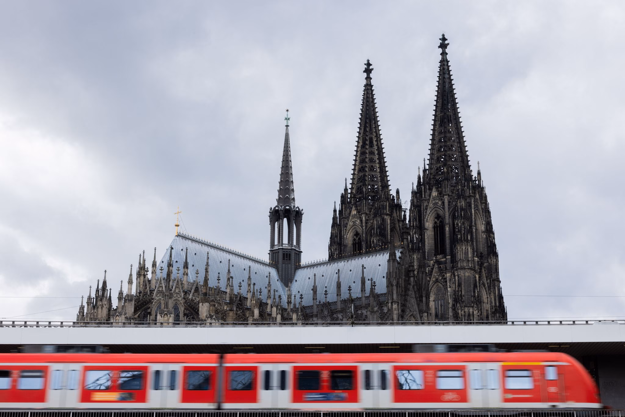 Regionalbahn fährt vor dem kölner dom in den hauptbahnhof ein