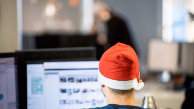 Ein mann sitzt mit weihnachtsmütze im büro