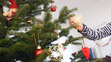 Mädchen schmückt einen weihnachtsbaum