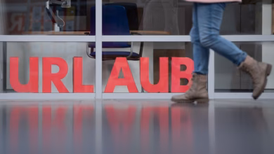 Eine frau läuft an den buchstaben urlaub vorbei