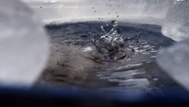 Wasser tropft in eine von eis umgebene regentonne