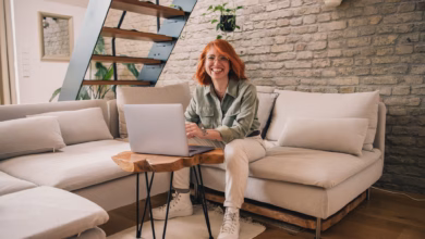 Eine frau am laptop sitzt auf einem sofa