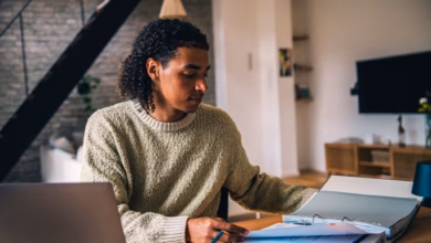 Ein mann vor einem aktenordner und einem laptop