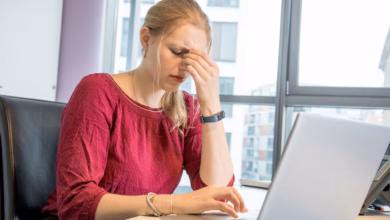 Eine frau reibt sich die augen am arbeitsplatz