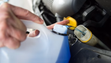 Mann füllt frostschutzmittel im auto nach