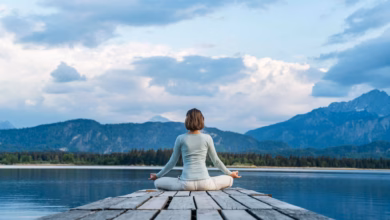 Eine frau sitzt auf einem steg und meditiert
