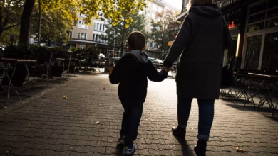 Einefrau hält ein kijd an der hand