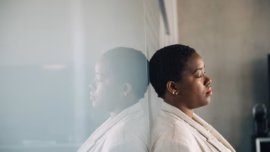 Eine junge frau lehnt nachdenklich an einer glaswand